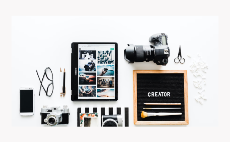 A flat layout of creator props, such as a smartphone, a camera and a tablet.