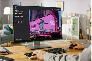 Silvercast Media case study by Lounge Lizard shown on a desktop monitor, featuring a website mockup with a left-side navigation menu (“Portfolio,” “About Us,” “Get Social”) and a hero image of a stage performance in bright pink lighting.
